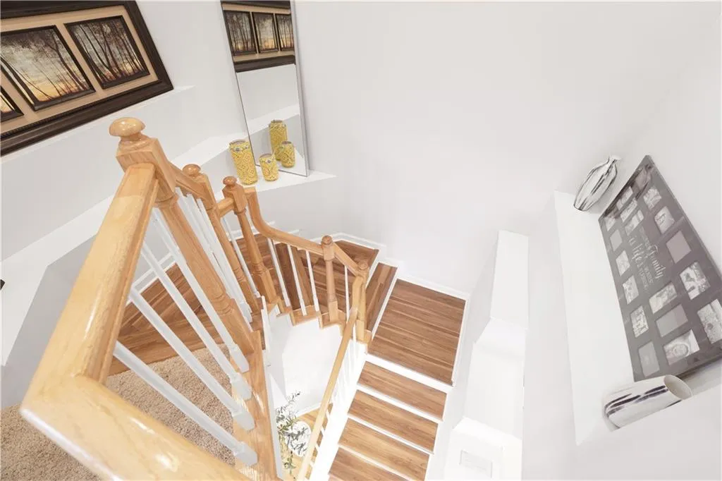Stairway with wood finished floors and baseboards
