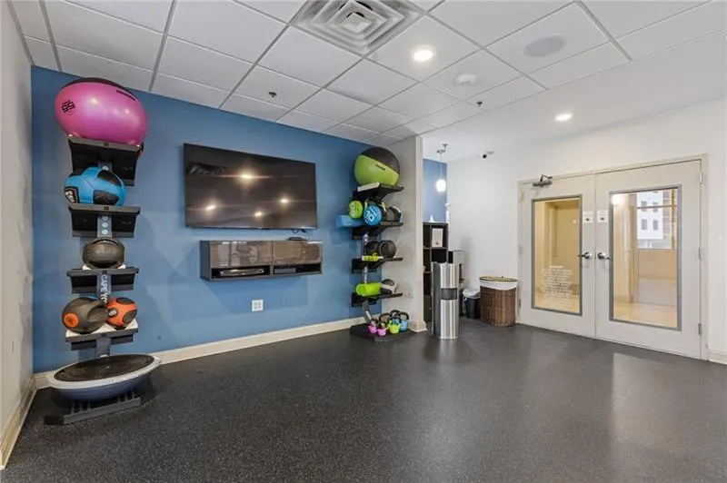 Workout room featuring a drop ceiling and french doors