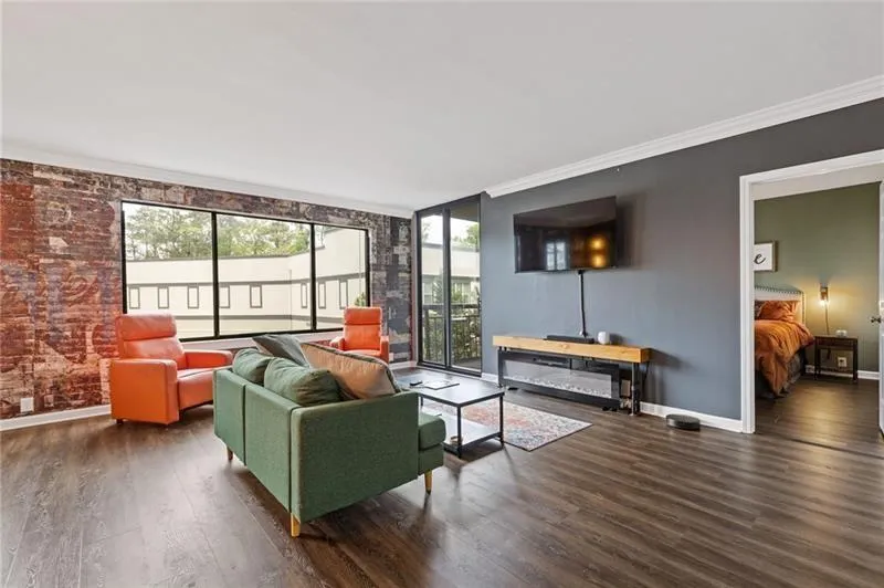 Living room featuring crown molding and dark wood-type flooring