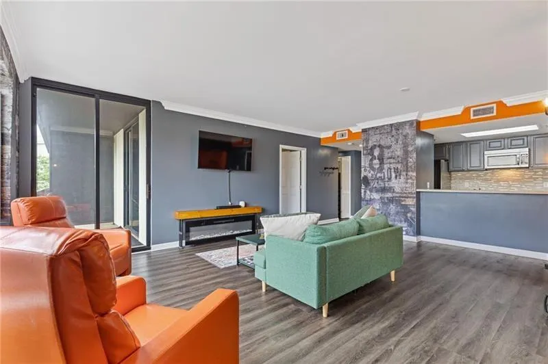 Living area featuring ornamental molding and dark wood-type flooring