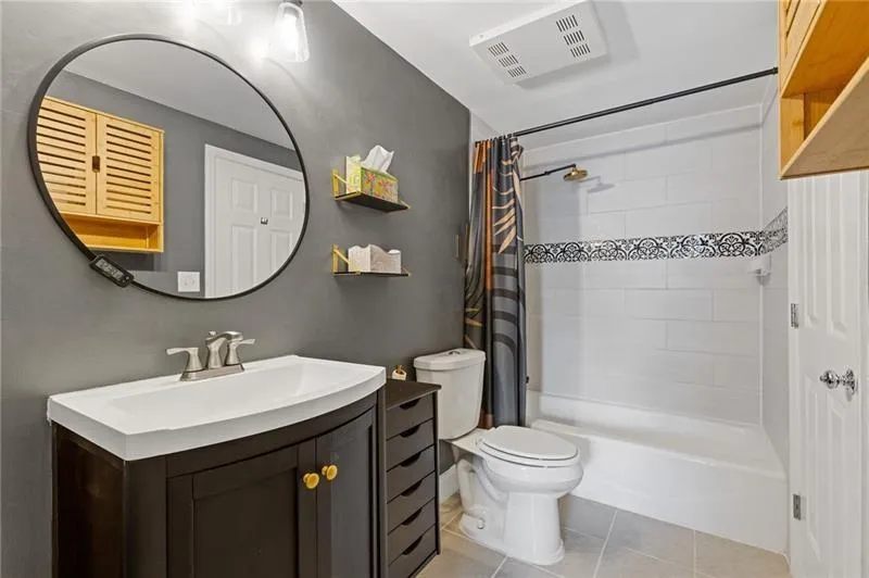 Full bath with vanity, light tile patterned floors, and shower / bath combination with curtain