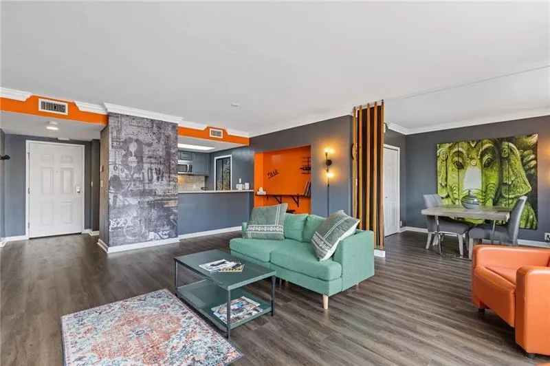 Living area featuring ornamental molding and dark wood-type flooring