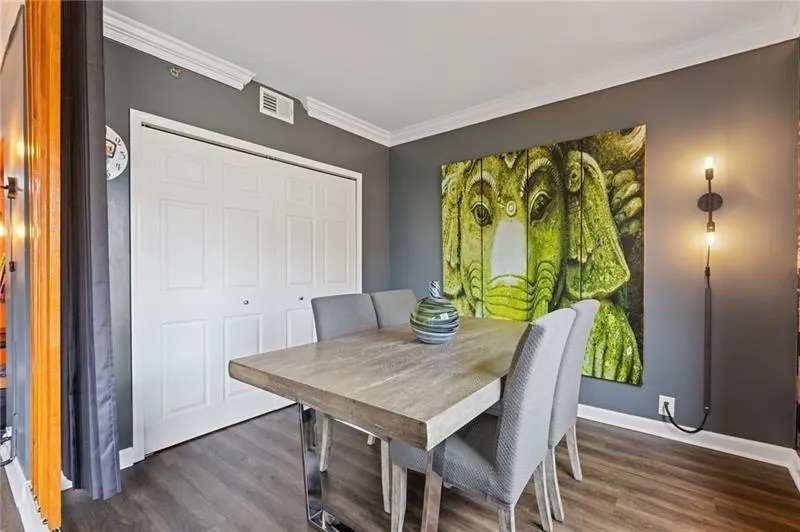 Dining space with crown molding and dark wood finished floors