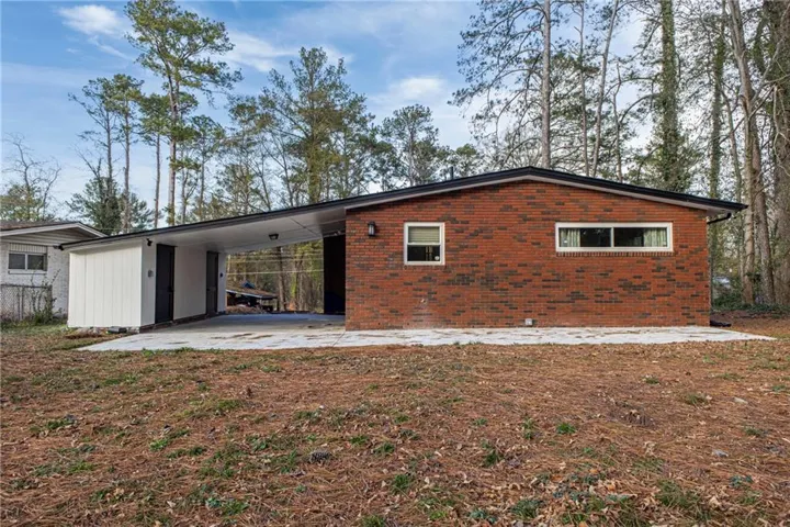 Brick exterior with an attached carport and an extended concrete patio