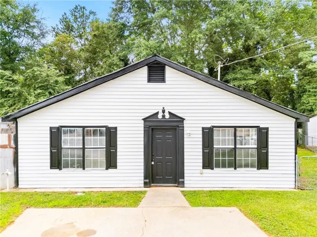 White siding exterior with a black gable roof and matching black shutters