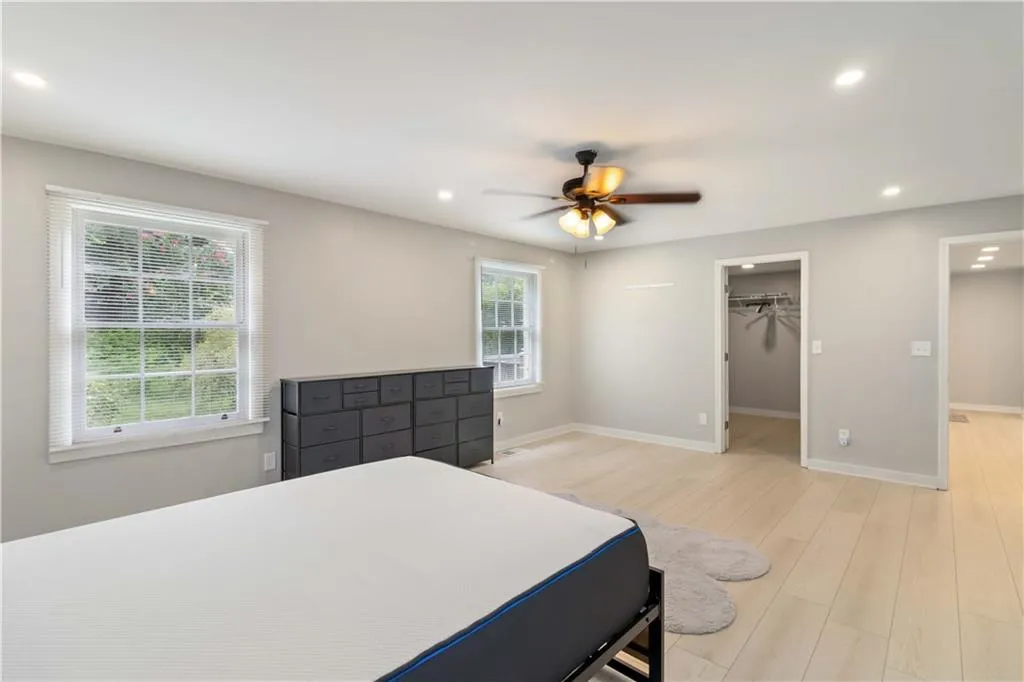 Bedroom featuring light wood-style flooring, a walk in closet, recessed lighting, and ceiling fan
