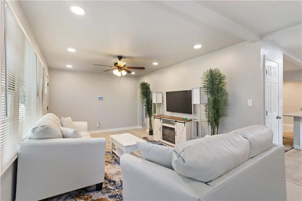 Living area with recessed lighting, a ceiling fan, and a fireplace