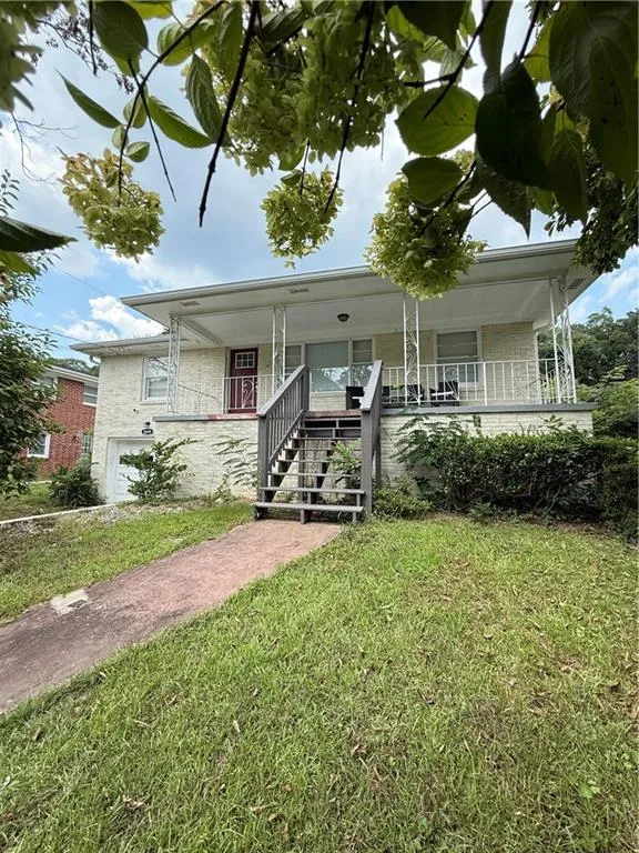 View of front facade featuring stairway, an attached garage, covered porch, and a front yard