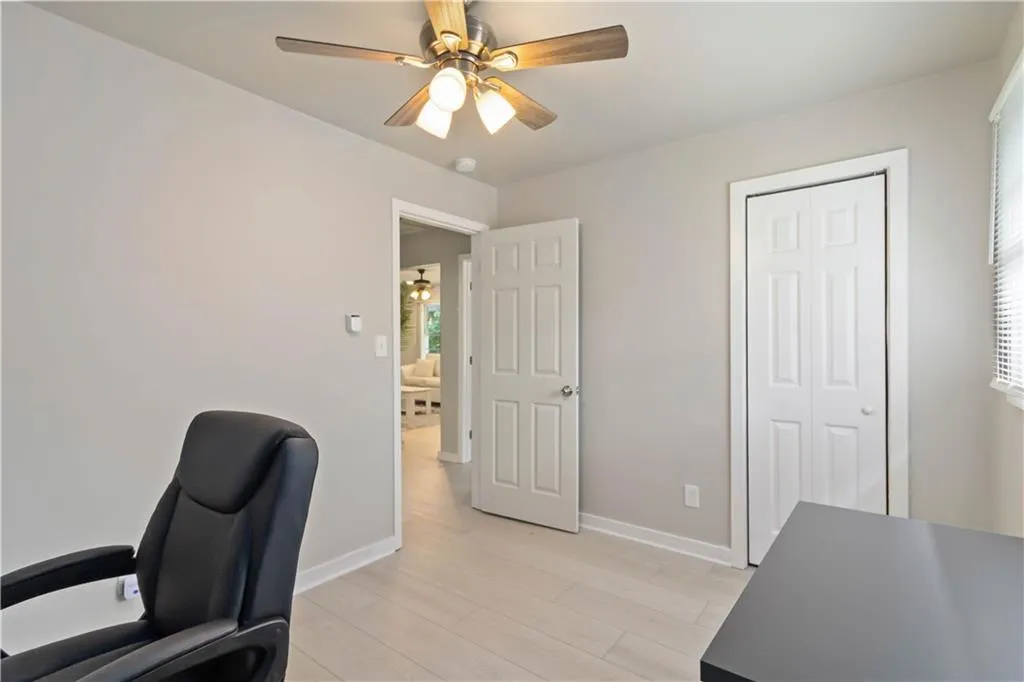 Office area featuring light wood-style flooring and ceiling fan