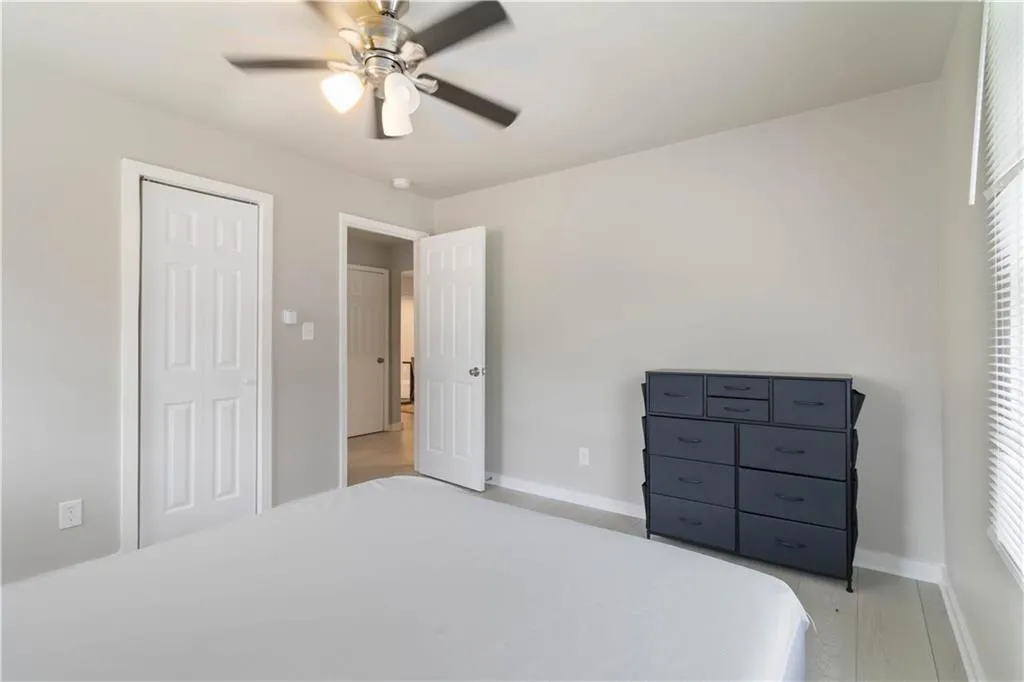 Bedroom featuring ceiling fan, light wood finished floors, and a closet