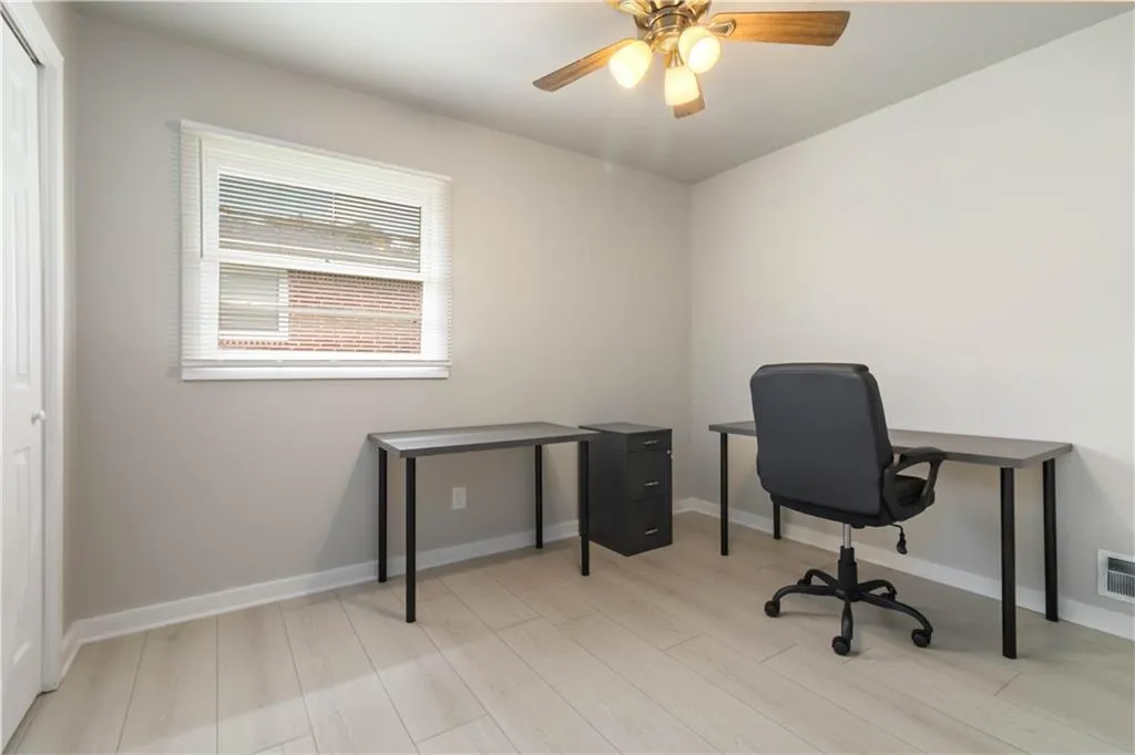 Office space with light wood-style flooring and ceiling fan