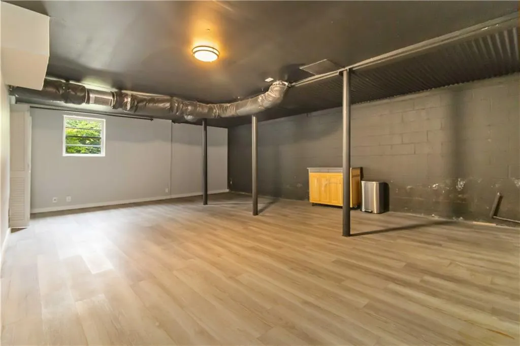 Basement featuring light wood-style floors and concrete block wall