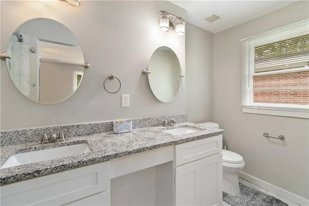Bathroom with light tile patterned flooring and double vanity