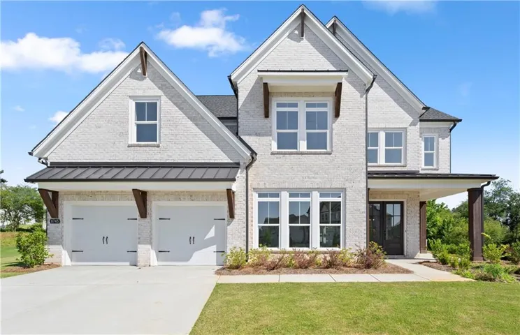 Two-story residence featuring light-colored brick masonry and contrasting dark trim accents