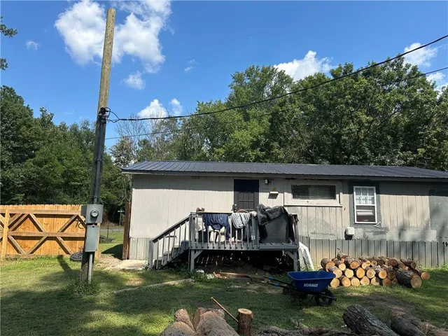 Rear view of house featuring a metal roof, a deck, and stairway