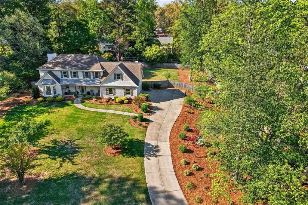View of subject property featuring a tree filled landscape