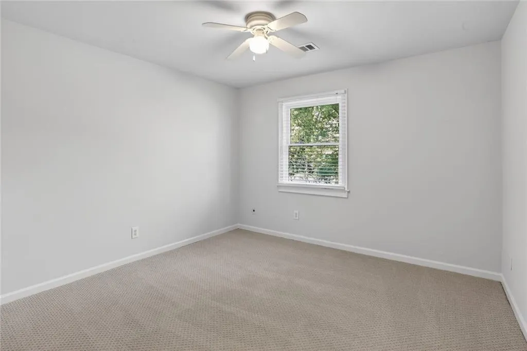 Carpeted spare room with baseboards and a ceiling fan