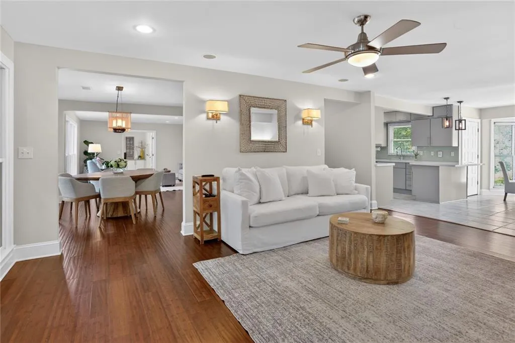 Living area with a ceiling fan and dark wood finished floors