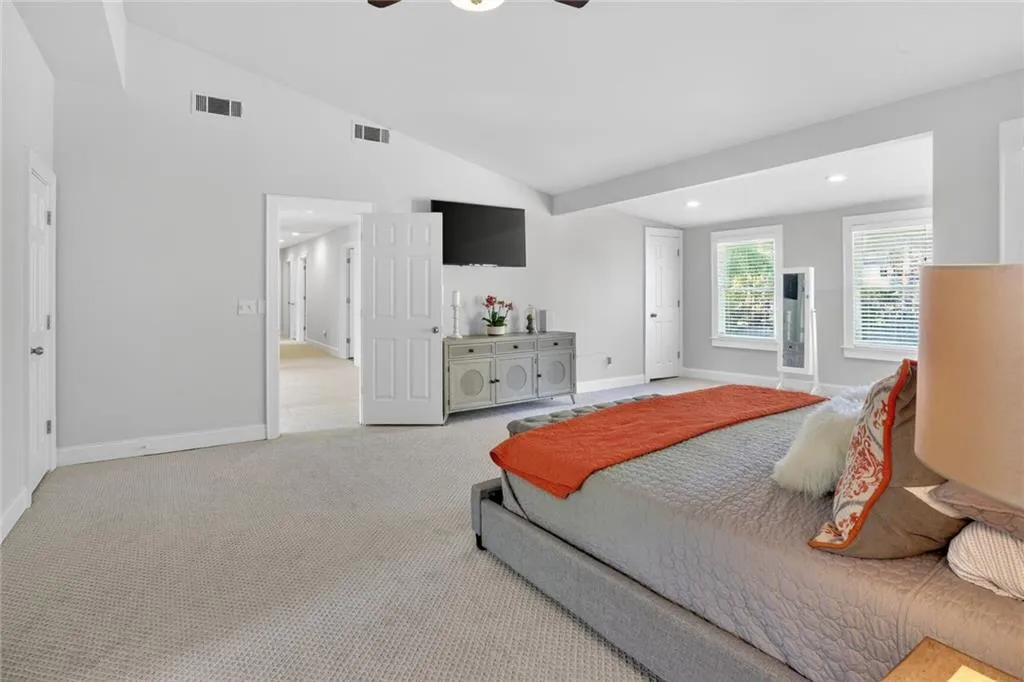 Bedroom featuring light carpet, vaulted ceiling, a ceiling fan, and recessed lighting