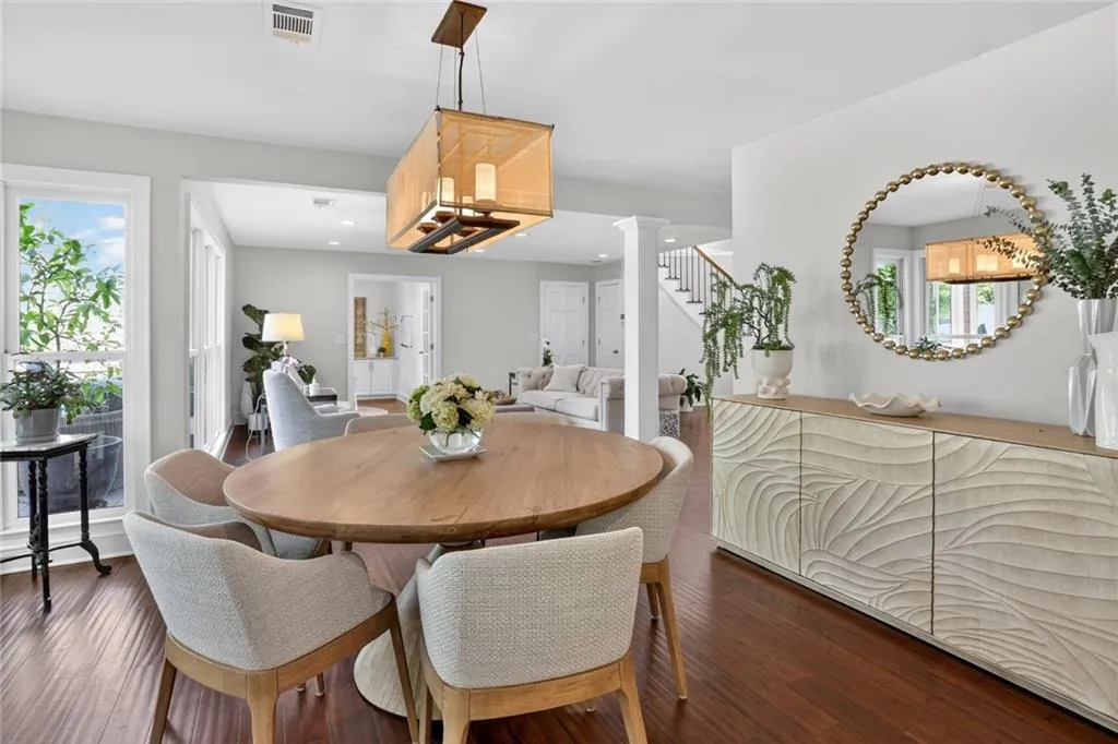 Dining room with wood-type flooring, healthy amount of natural light, and ornate columns