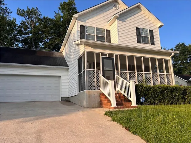 White siding exterior with black shutters, featuring a screened porch with lattice detailing