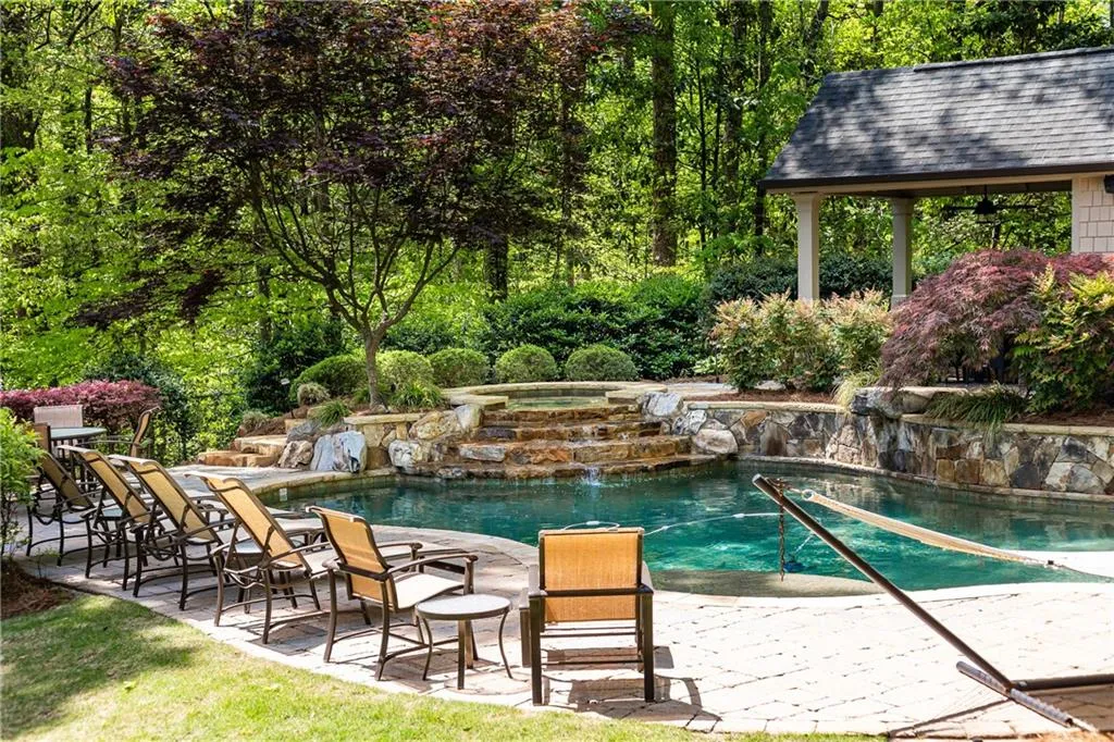 Beautiful pool with pool house blends nicely into the landscape