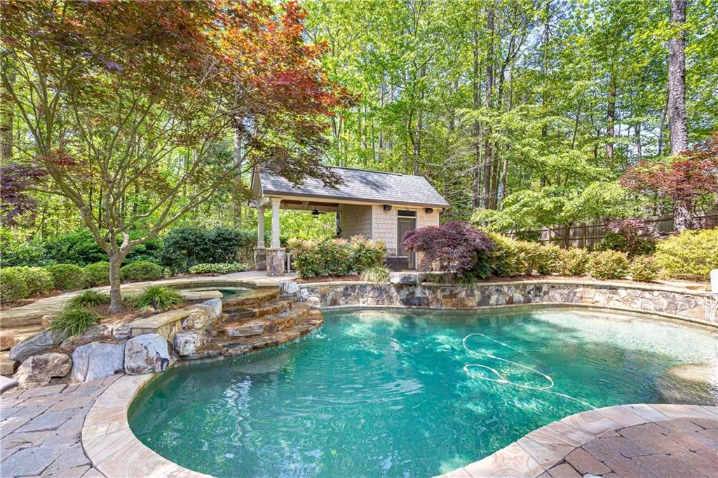 Pool house has dining area, outdoor grill, and full bathroom