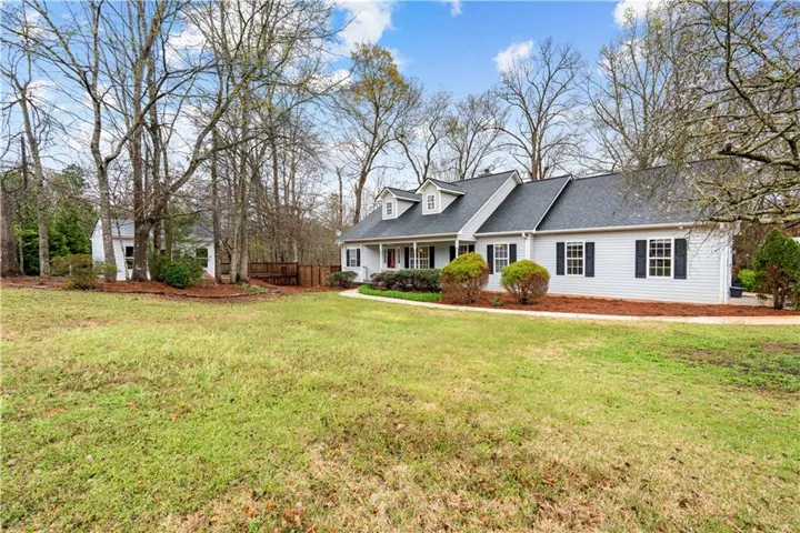 Cape cod-style house featuring covered porch and roof with shingles