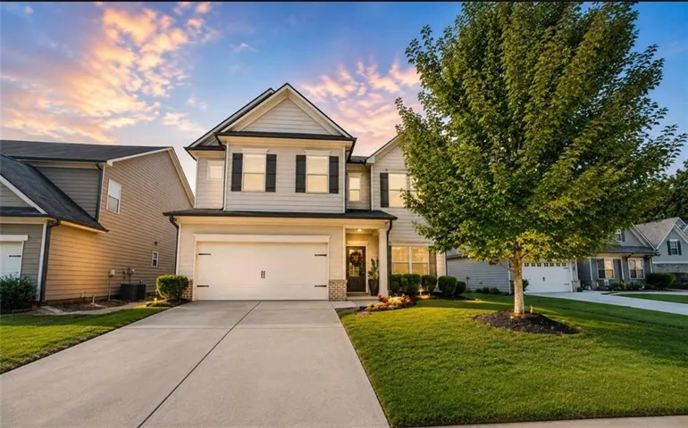 Two-story residence featuring light-toned siding, a two-car garage, and dark window shutters
