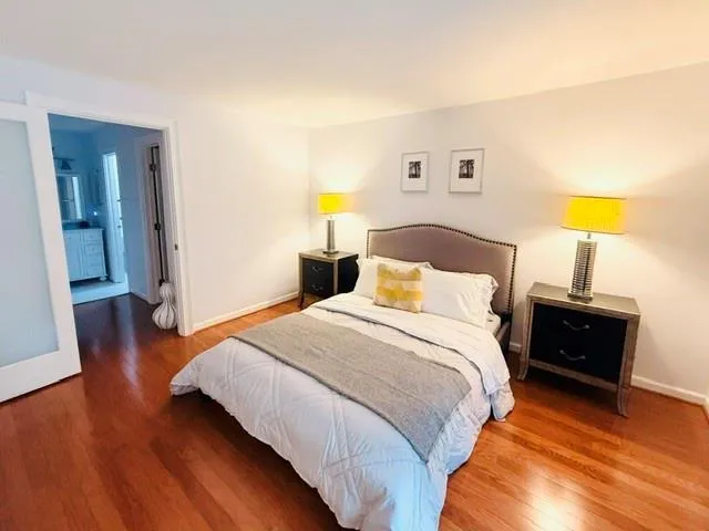 Hardwood flooring, white walls, and a frosted glass sliding door
