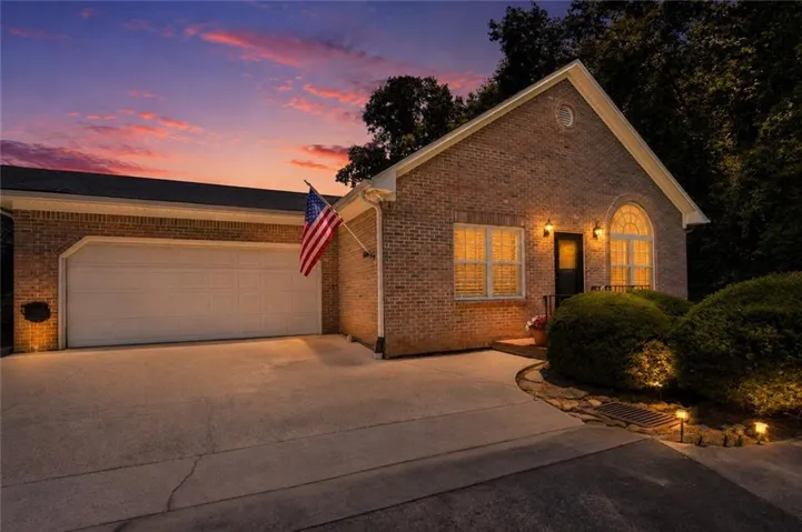 *virtually enhanced* Brick exterior with a prominent arched window and a two-car garage