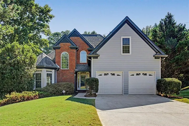 Brick and siding exterior with a two-car garage and concrete driveway