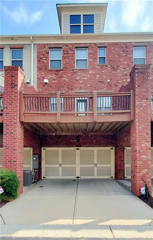 Back of house featuring a garage and central AC