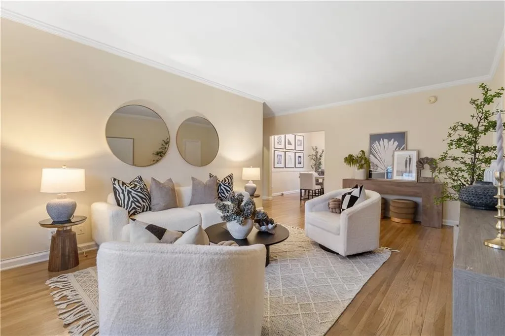 Living area featuring ornamental molding and light wood finished floors