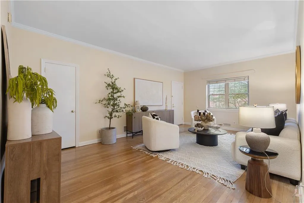 Living room with wood finished floors and ornamental molding