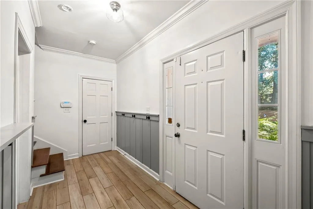 Entrance foyer featuring crown molding and light wood finished floors