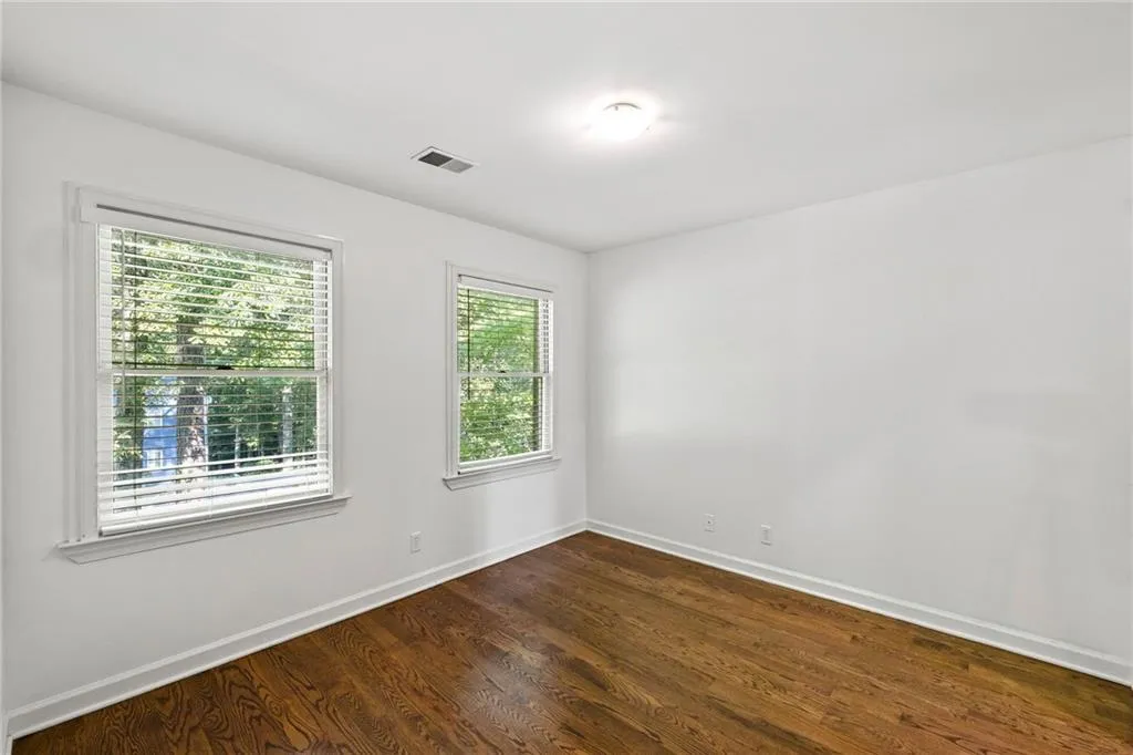 Empty room featuring dark wood finished floors and baseboards