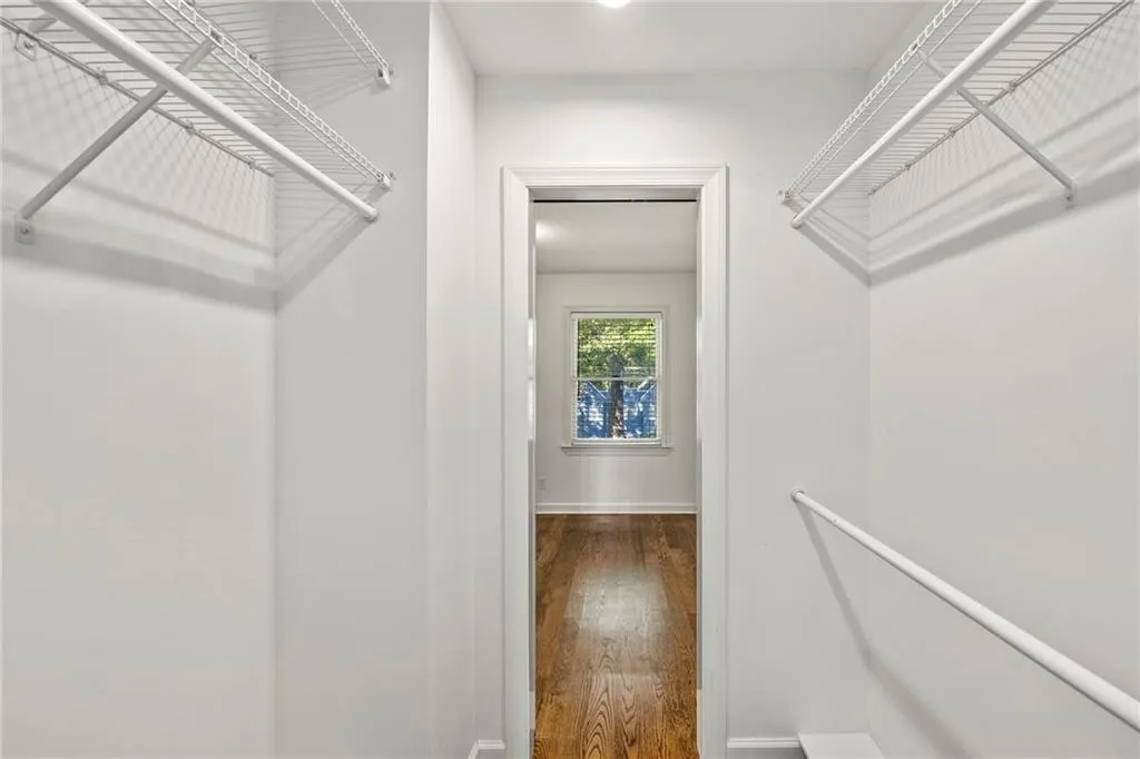 Walk in closet with wood finished floors