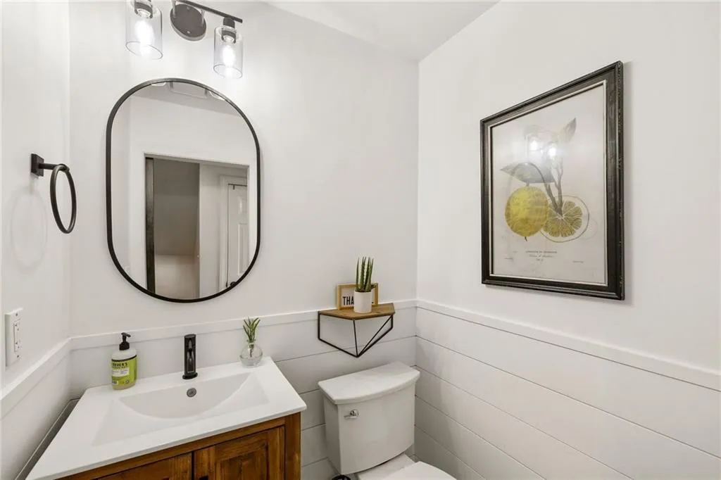 Half bath featuring vanity and wainscoting