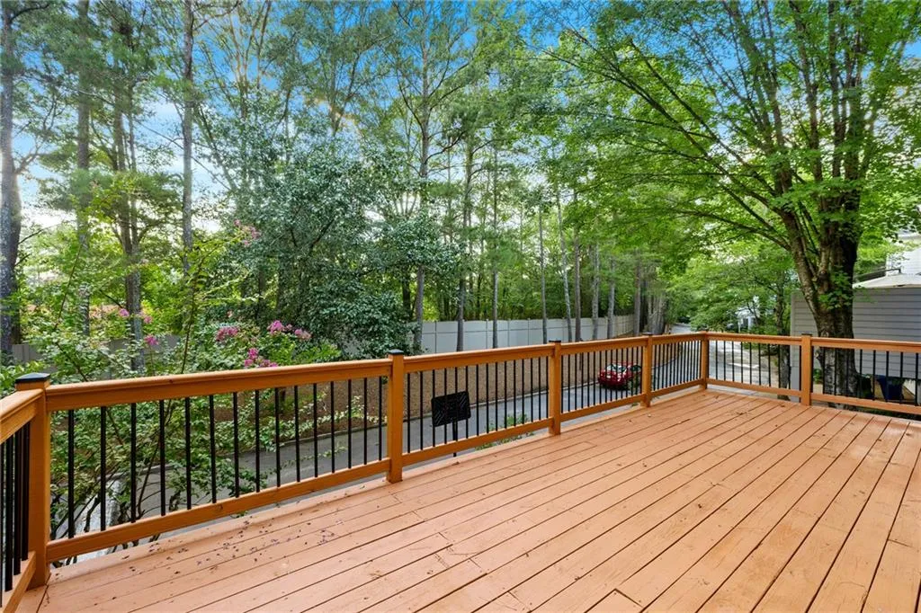 Wooden terrace featuring view of wooded area