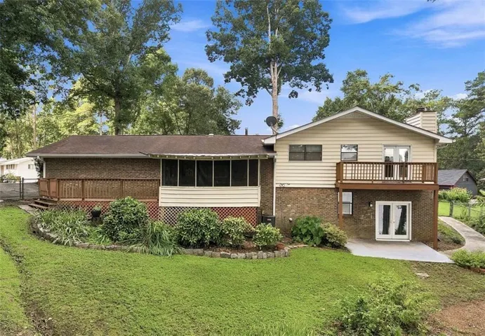 Multi-level rear exterior featuring brick and siding, a screened porch, and an upper-level wood deck