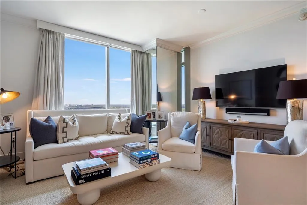 Floor-to-ceiling windows, crown molding, and a built-in media console with storage