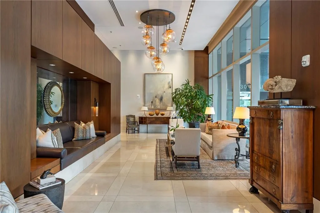 Wall-to-wall glazing, recessed ceiling lighting, and a multi-globe chandelier illuminate the space