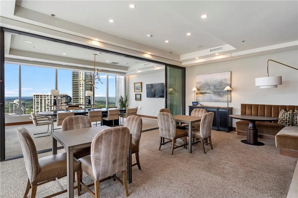 Expansive windows, recessed lighting, carpet flooring, full-height sliding glass panels, and a tray ceiling
