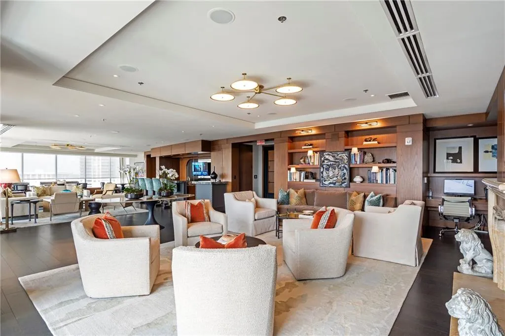 Recessed lighting, wood-finish flooring, built-in shelving, tray ceiling, and expansive windows