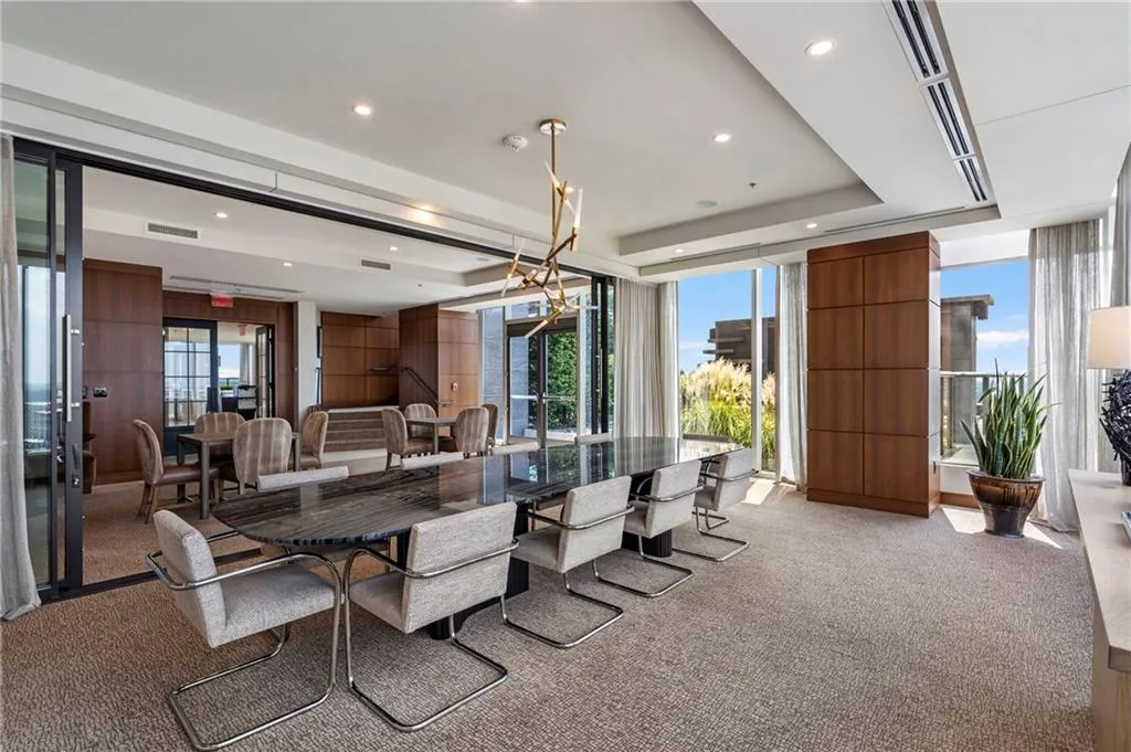 Spacious room with large windows, recessed lighting, wood-finish paneling, and a contemporary chandelier
