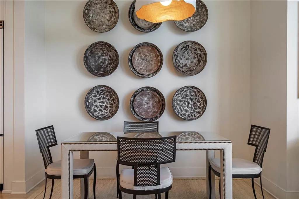 White walls with a textured wall art arrangement and a single pendant light fixture