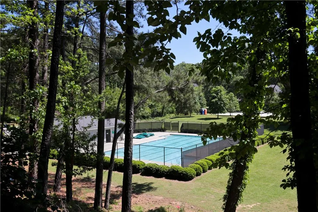 View of tennis court featuring a community pool