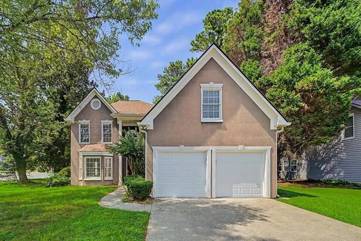 Two-car garage, bay window, landscaped front yard, and a curved walkway