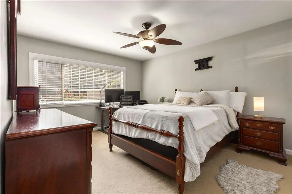 Carpeted bedroom with exterior window .